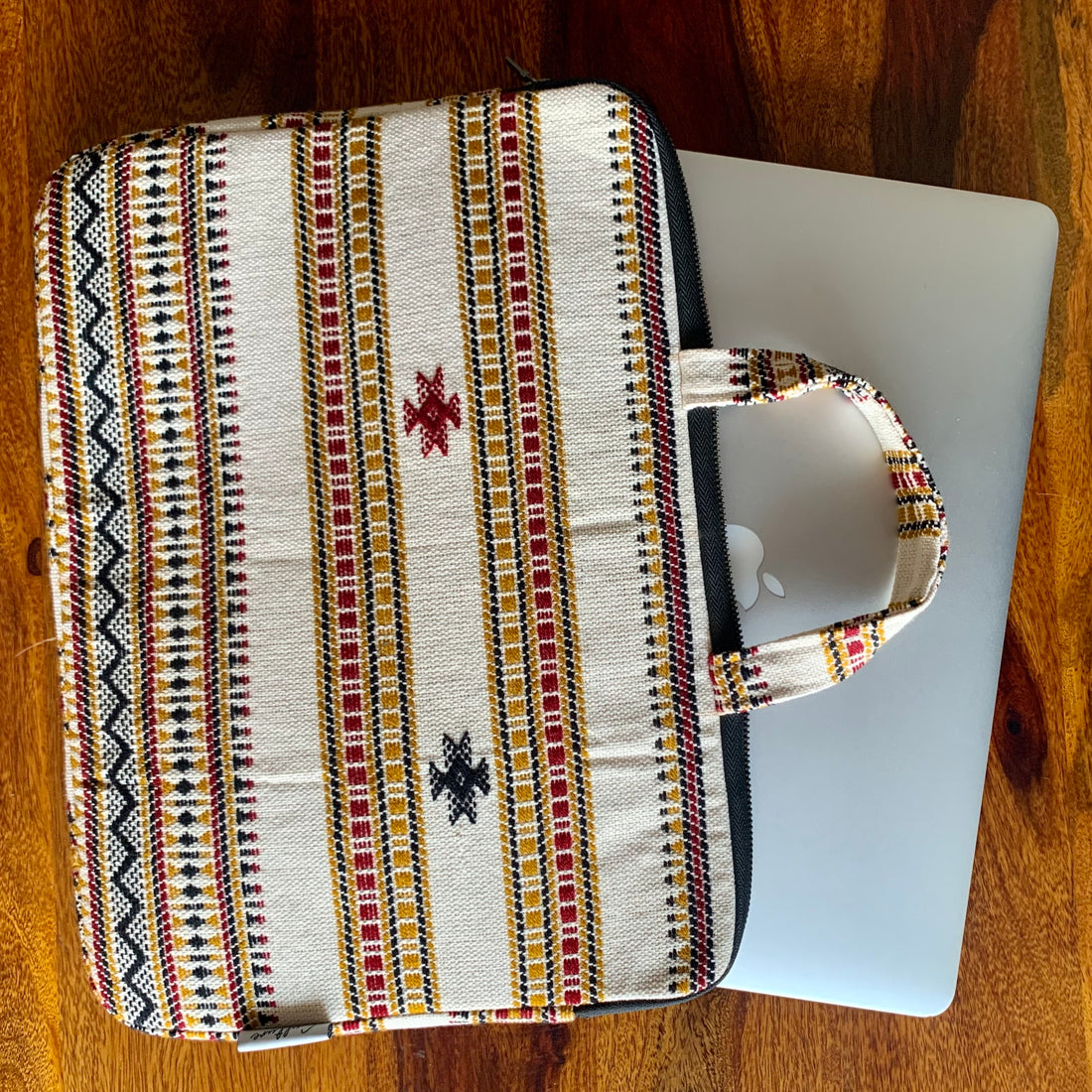 KORA Handloom Jacquard Laptop Bag featuring intricate handwoven patterns in vibrant colors, showcasing a stylish and functional design perfect for carrying laptops and essentials